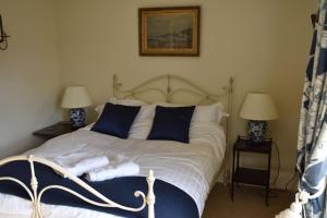 洛尔斯劳特Riverside Cottage的一间卧室配有一张带蓝色和白色枕头的床
