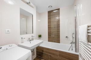 布拉迪斯拉发维尔戈公寓式酒店的白色的浴室设有水槽和浴缸。