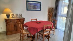 图卢兹COSY LODGE GITE APPARTEMENT MEUBLE CiTY BREAK的餐桌和椅子,配有红色桌布