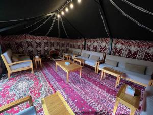 欧奈宰Ezdan Chalet的帐篷内配有沙发和桌子的房间