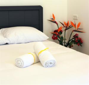 Refael Garden Villa的床上的两条滚毛巾,花瓶