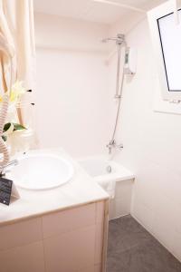 锡切斯苏布尔酒店的白色的浴室设有水槽和淋浴。