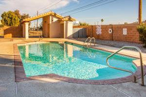 优马Renovated Yuma Home with Community Pool!的庭院里的一个蓝色海水游泳池