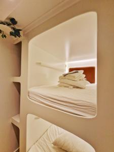 海牙金鹳青年旅舍的白色客房,架子上配有白色毛巾