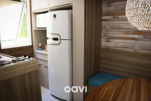 皮帕Qavi - Apartamento no Centro de Pipa #Solar163的桌子旁的厨房里的一个白色冰箱