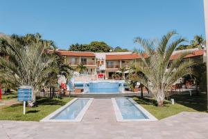 皮帕Qavi - Apartamento no Centro de Pipa #Solar163的一个带游泳池和棕榈树的度假村