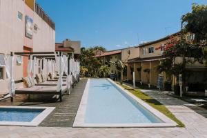 皮帕Qavi - Apartamento no Centro de Pipa #Solar163的一座带椅子的建筑旁边的游泳池