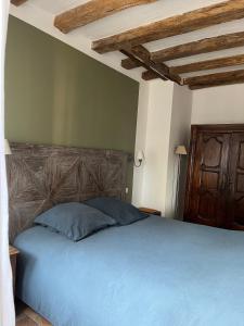 NazellesChâteau de Nazelles Amboise的一间卧室配有一张蓝色的床和木制床头板