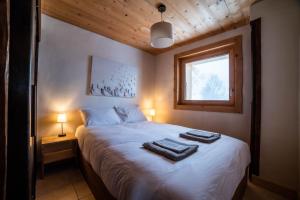 梅杰夫Chalet vue Mont-Blanc, +4 Chambres, cheminée的一间卧室配有一张床,上面有两条毛巾