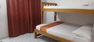 托卢Hostal Girasoles Tolu的一间卧室设有两张双层床和红色窗帘