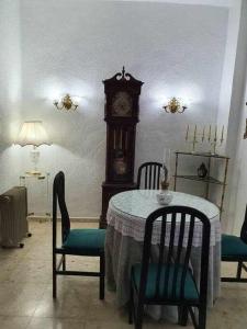 格拉纳达Carmen de la Sultana的一张桌子和椅子,在房间里装有祖父钟