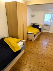 拉康提内勒Petite Pause Oléronaise的一间卧室设有两张床、一个橱柜和木地板。