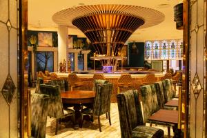 纳斯劳勒斯酒店的一间带桌椅的餐厅和一间酒吧