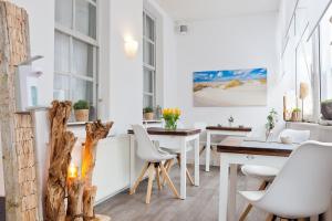 诺德奈Haus Menno Janssen - Doppelzimmer的一间配备有白色椅子和桌子的用餐室