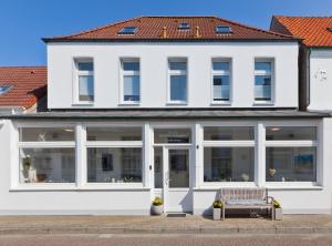 诺德奈Haus Menno Janssen - Doppelzimmer的前面有长凳的白色建筑