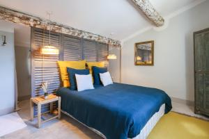 阿普特La Madone的一间卧室配有蓝色的床和黄色枕头