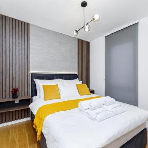 诺维萨德Divine & Delight Apartments的一间卧室配有一张带黄色枕头的大床