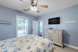 罗克波特Packsaddle Beach House的一间卧室配有一张床和一台平面电视