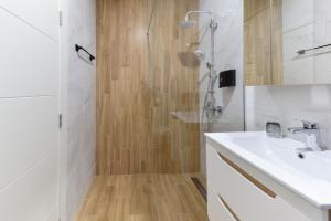 诺维萨德Divine & Delight Apartments的带淋浴和盥洗盆的白色浴室