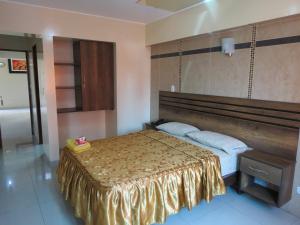 利马HOTEL ESTRELLA的一间卧室配有一张带金色床罩的床