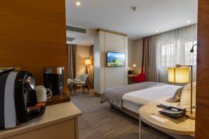 特拉布宗Kuhla Hotel的酒店客房设有一张床和一张带电视的书桌。