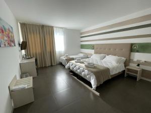 基亚拉蒙泰-古尔菲Hotel Grel的一间卧室设有两张床和大窗户