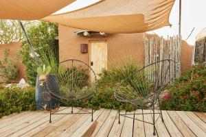 特灵瓜Desert Pearl ⁠— Quick Drive from Big Bend的木制甲板上的两把椅子和一把遮阳伞