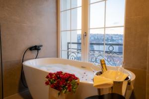 普里什蒂纳Downtown Apartments的带鲜花的浴缸的浴室