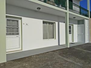 CalhetaRua de Baixo Apartments的白色的建筑,设有2扇窗户和阳台