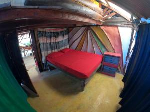 卡普兰干Reciclarte Galería Hostal的圆顶帐篷内的红色床的顶部景色