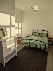 诺里奇Philippa Court Grade II townhouse- 3 bedrooms- free parking的一间卧室配有一张带绿色棉被的床