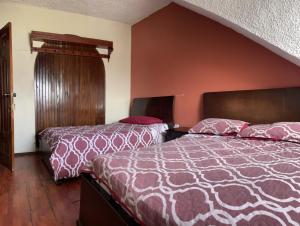 昆卡ALOJAMIENTOS HOSTAL REST HOUSE的一间酒店客房,房间内设有两张床