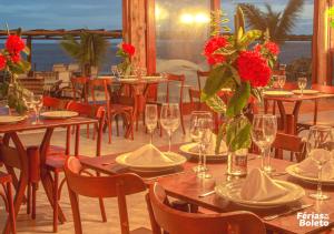 塞古罗港PSP Resort All Inclusive的餐厅设有桌椅,并配以红色的鲜花