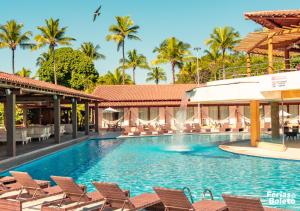 塞古罗港PSP Resort All Inclusive的一个带椅子和棕榈树的度假村游泳池
