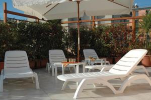 洛阿诺Residence La Casetta的一组白色的桌椅和一把伞