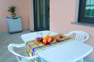洛阿诺Residence La Casetta的一张带水果和饮料的白色桌子