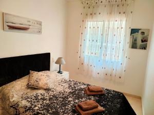 托雷维耶哈Casas Holiday - Playa del Cura的一间卧室配有一张床,上面有两条毛巾