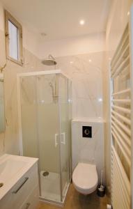 芒通Pavillon Lilly的一间带卫生间和玻璃淋浴间的浴室