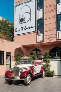 斋浦尔Bur'Dera - a Boutique Luxury Hotel的停在大楼前的红色和白色旧车