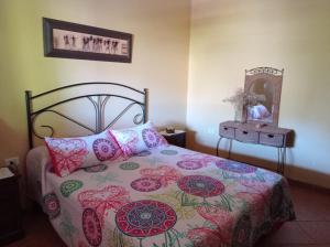 AlojeraApartamento La Punta的一间卧室配有一张带花卉床罩和镜子的床