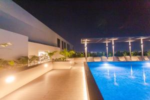 阿克拉Accra Luxury Apartments @ The Lennox的夜间屋顶的游泳池