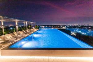 阿克拉Accra Luxury Apartments @ The Lennox的一座游泳池,在晚上在一座建筑的顶部