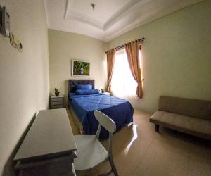 日惹Gated 3BR Residence - 10 mins from Malioboro的一间卧室设有蓝色的床和窗户。