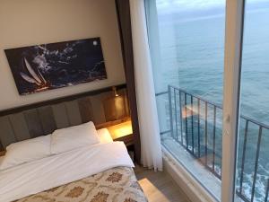 特拉布宗The Marine Hotel的一间卧室设有一张床和一个海景阳台