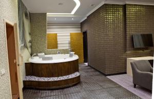 哈尔科夫奇洛夫酒店的一间带浴缸的浴室和一台电视。