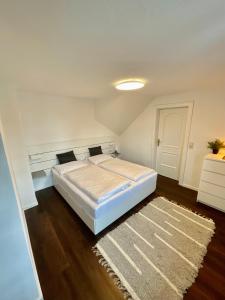拉姆绍达赫斯坦Appartements Die Bergretter的卧室配有白色的床和地毯。