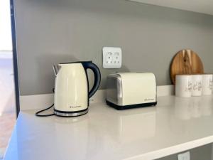 兰格班Langebaan Holiday Home的厨房柜台上配有咖啡设施和烤面包机。