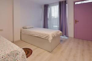 阿拉德Pensiune Arada的一间卧室配有一张床和一个紫色的门