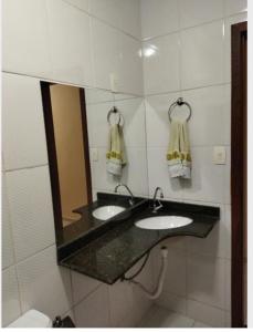 伊帕廷加Apartamento de luxo com 2 quartos, sala com sacada, cozinha área de serviço e 1 banheiro social.的浴室设有2个水槽和镜子