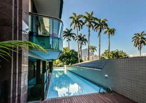 里约热内卢Flat - Leblon的棕榈树建筑旁边的游泳池